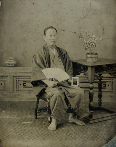 Japanese Man in Traditional Garb Holding Another Ambrotype of His Portrait in Western-Style Clothing