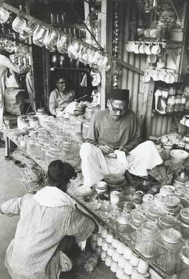 Anonymous - Indian Merchant Totals up Sales in a Kitchen Wares Store Anonymous - Indian Merchant Totals up Sales in a Kitchen Wares Store