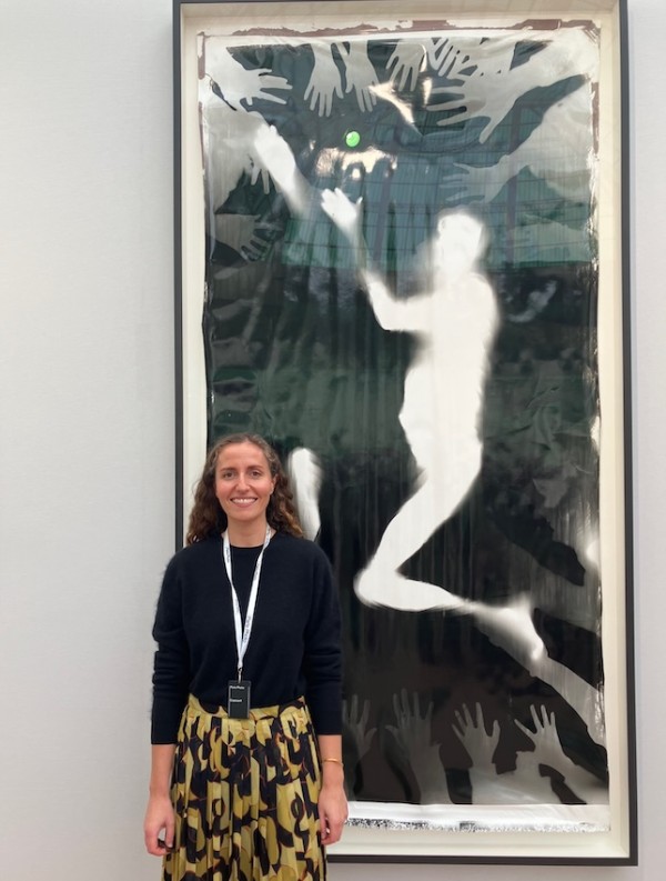 Tessa Cranfield of Richard Saltoun Gallery standing next to a monumental work by Ulay entitled "Performing Light".  Ulay is the pseudonym of Frank Uwe Laysiepen.